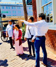 Black history tour guide speaking with visitors on a Charleston sidewalk during an educational Gullah Geechee walking tour